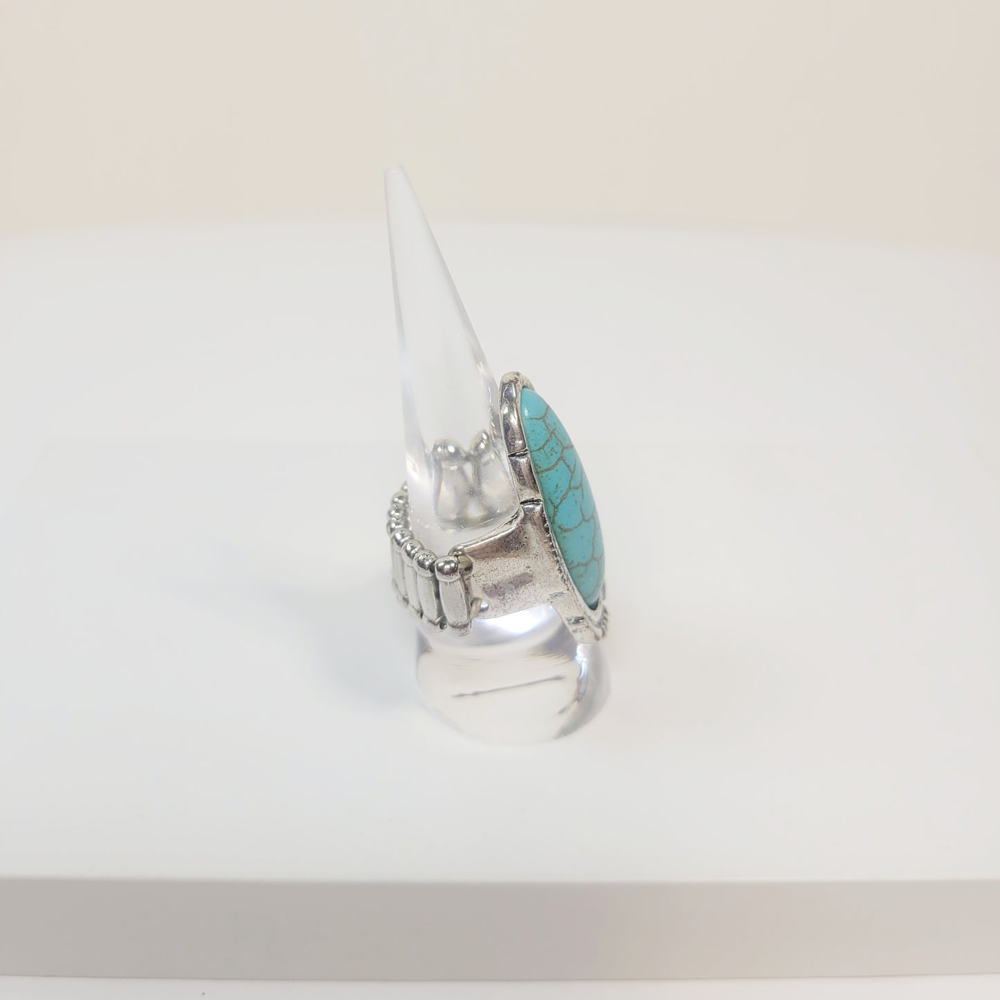 Oval Turquoise Ring. Silver-toned and elastic band.